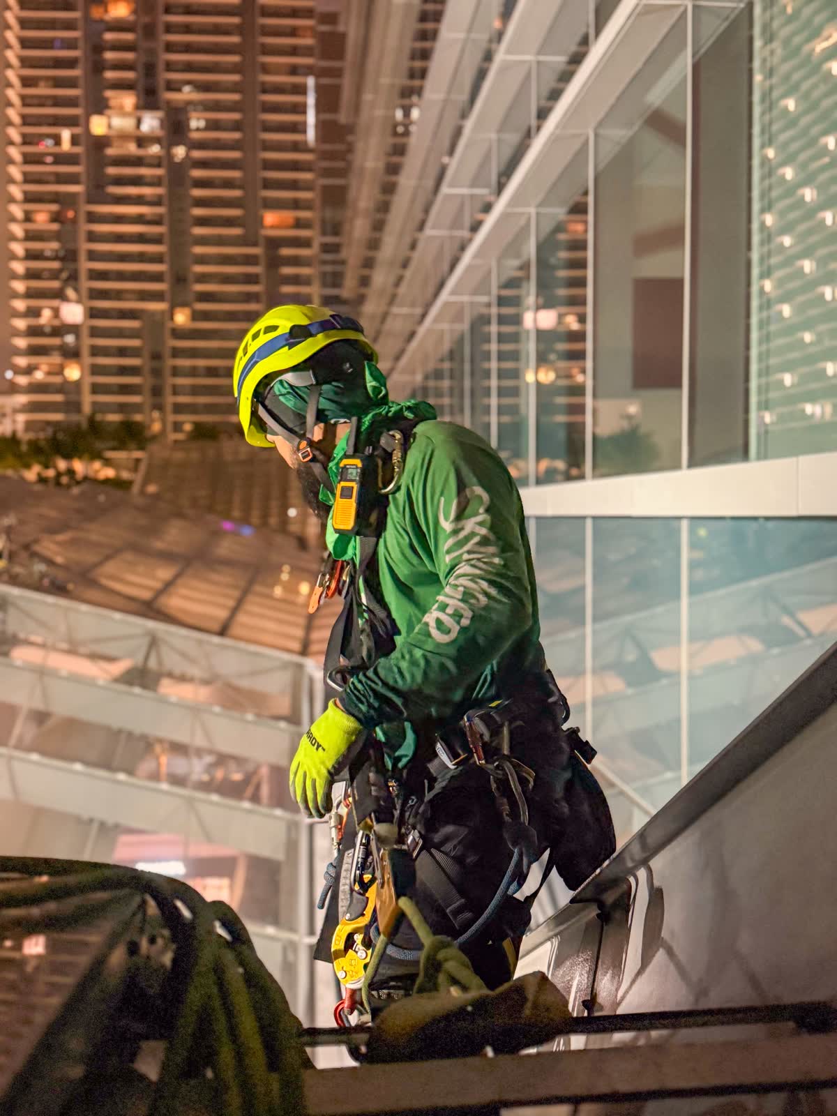 SKYHANGER 2 IRATA-certified technician performing rope access work on high-rise glass facade at night
