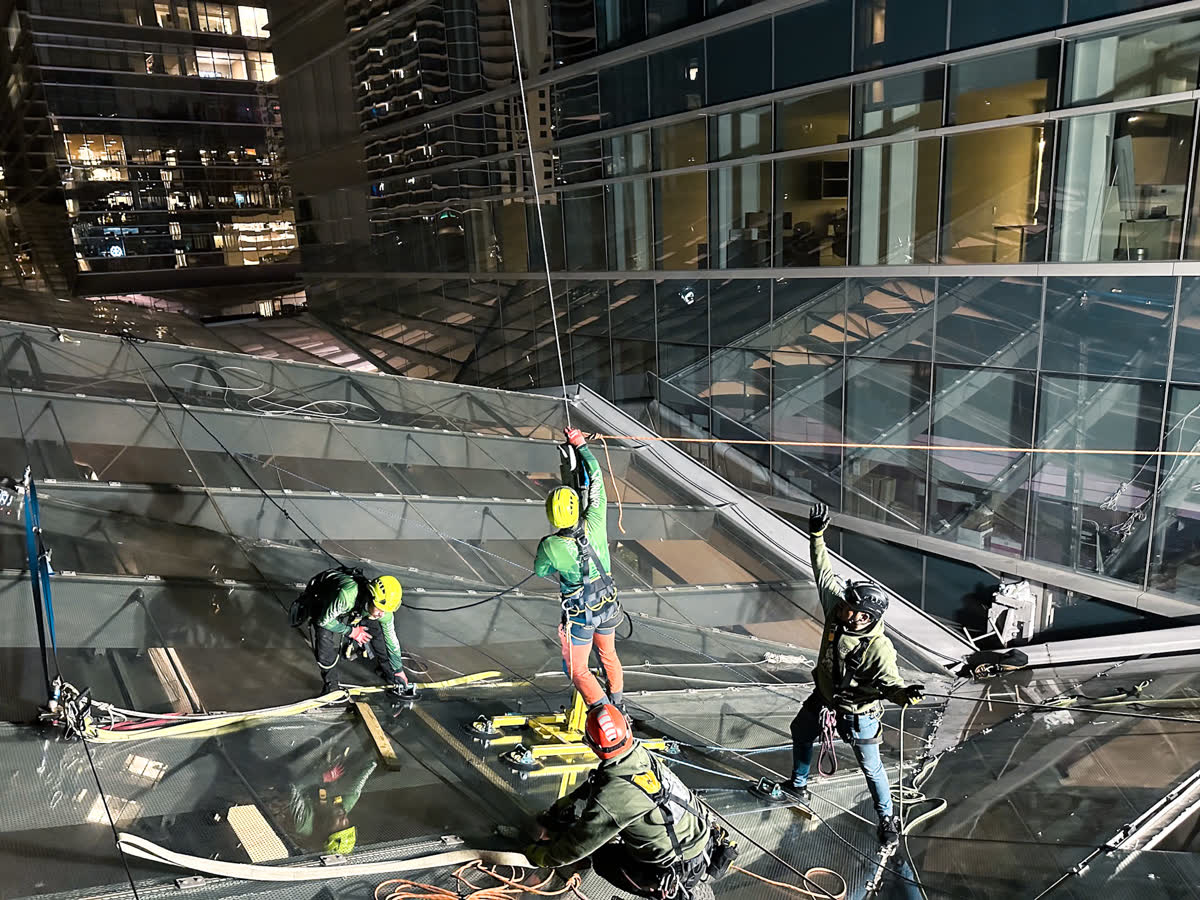 SKYHANGER 2 team working on glass with city lights